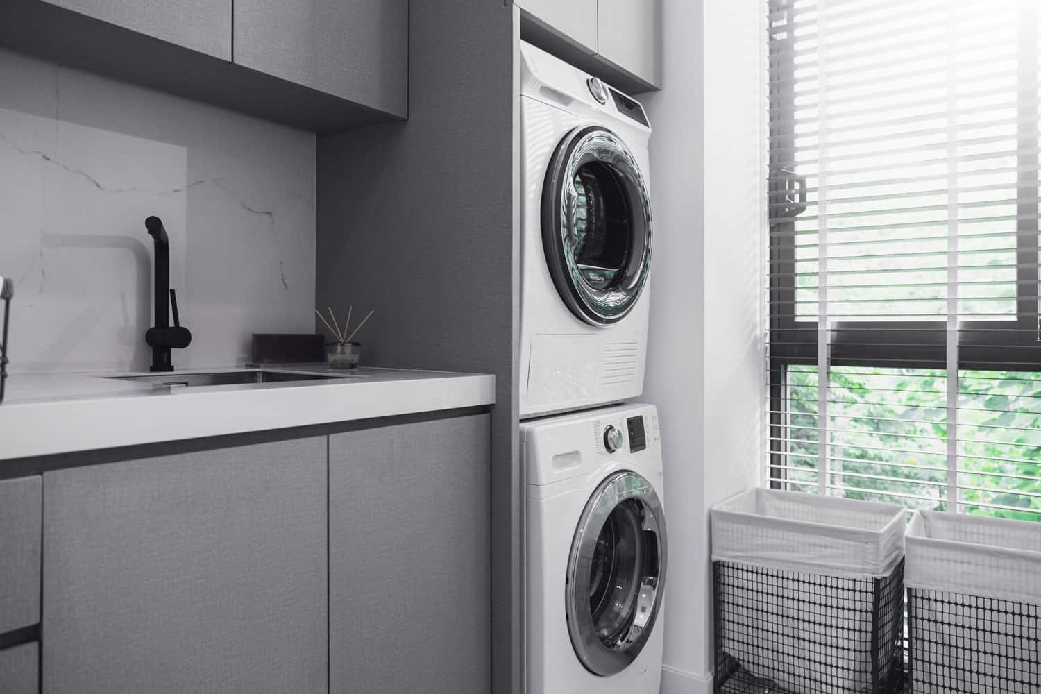 A-washing-machine-and-a-dryer-on-top-of-it-in-the-laundry-room