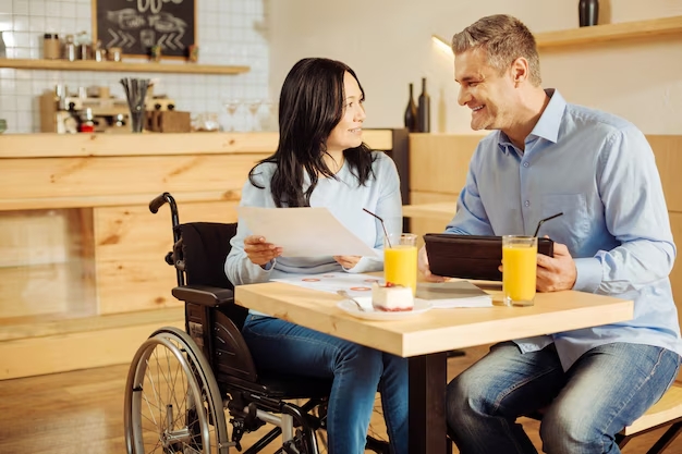 attractive-exuberant-disabled-woman-handsome-happy-blond-man-smiling-discussing-work-while-sitting-c