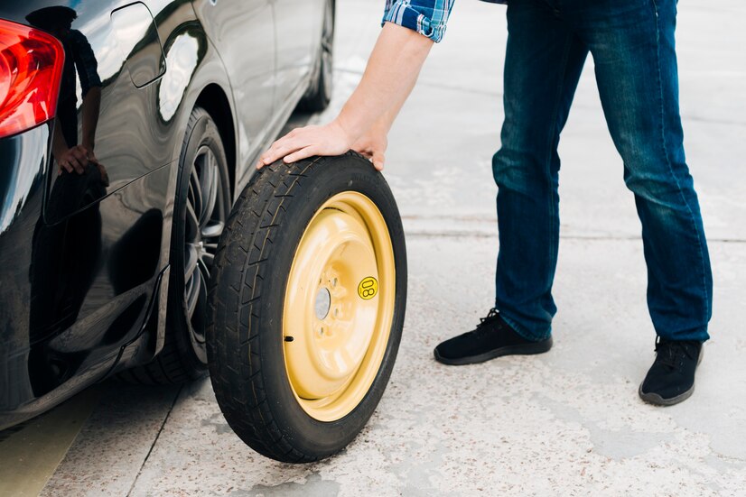 man-changing-car-tire-with-spare-tire_23-2148258057