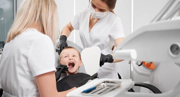 dentist-assistant-examining-child-teeth-dental-office_651396-1892