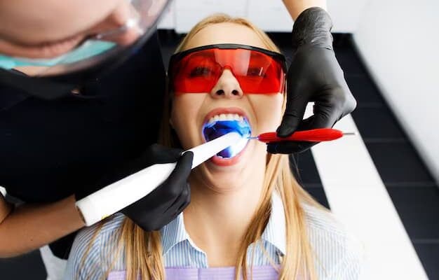 patient-red-glasses-sits-chair-dentist-office-while-doctor-whiten-her-teeth_8353-1665