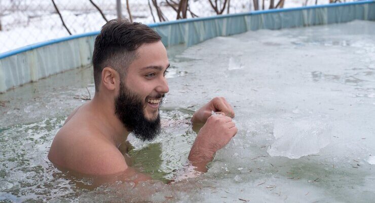 young-smiling-bearded-man-ice-hole-frozen-swimming-pool-winter-day_665346-151199