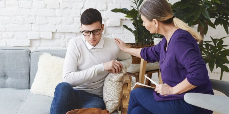 candid-shot-casually-dressed-professional-woman-psychotherapist-her-fifties-touching-her-young-male-patient-by-shoulder-while-having-counseling-session-expressing-sympathy-support_344912-1934