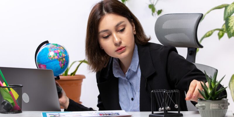 front-view-beautiful-young-businesswoman-black-jacket-blue-shirt-observing-little-globe-front-table-business-job-office (1) (1)