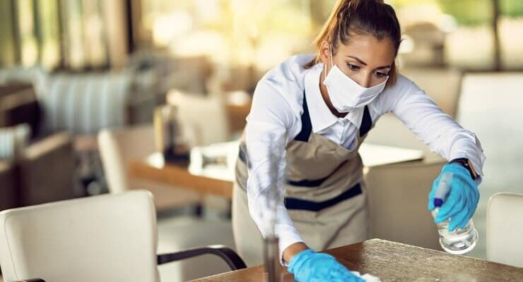 waitress-cleaning-tables-with-disinfectant-wearing-protective-face-mask-cafe_637285-8934