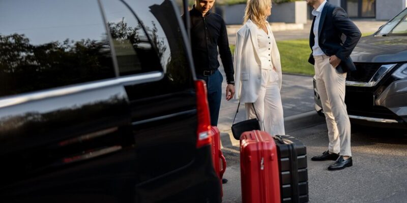 business-couple-near-minivan-taxi-with-suitcases-chauffeur_506452-23521